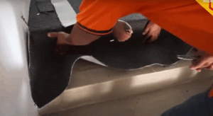 Expert installers fitting and trimming black office carpet on staircase to keep a clean appearance.